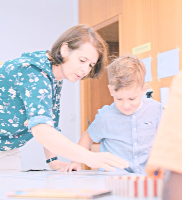 Une formatrice accompagne un jeune enfant dans l'apprentissage de l'allemand avant sa scolarité obligatoire pendant une rencontre du Kinderklub.