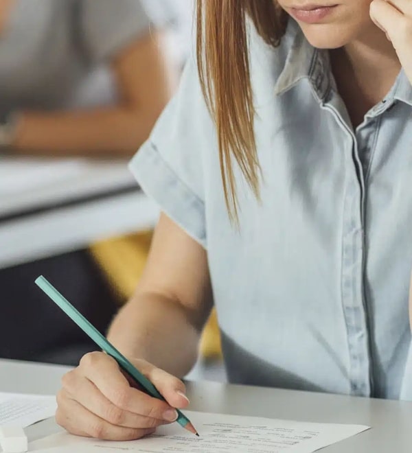 Une étudiante passe un examen officiel en allemand dans sa salle de cours pour réussir sa maturité